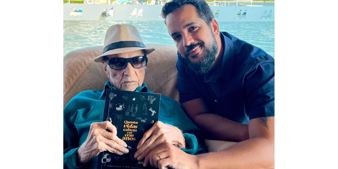 Rafael Ferrer e seu avô Saulo com o livro "Quantas vidas cabem em 100 anos".